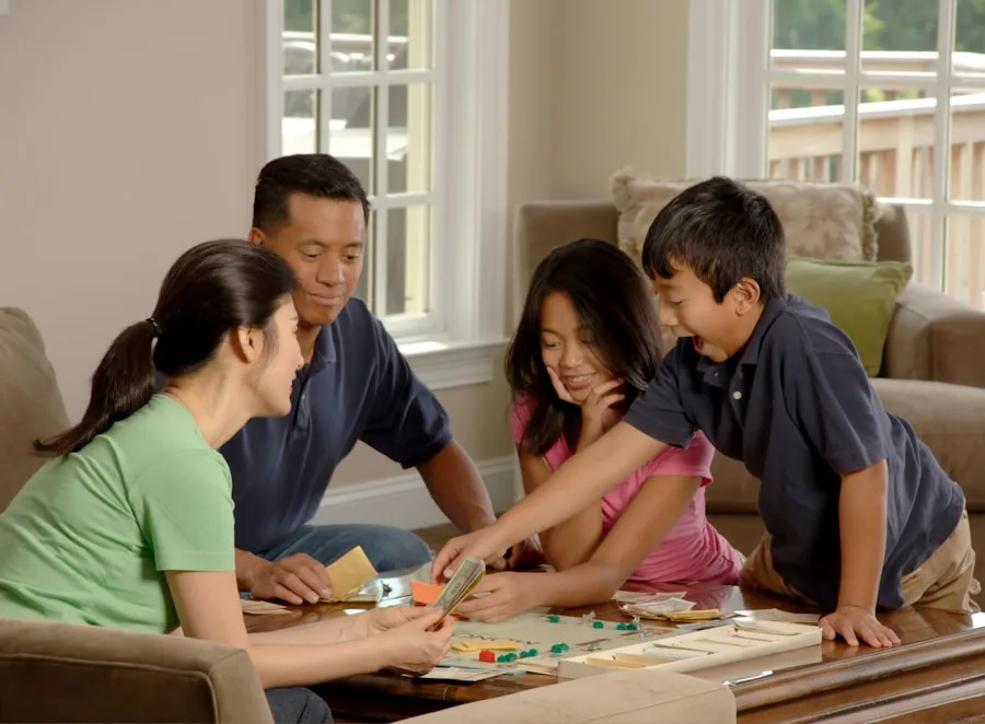 Asian family of four playing a board game together in their living room
